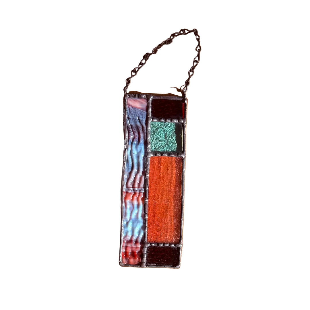 Decorative stained glass wall hanging with geometric design on a white surface