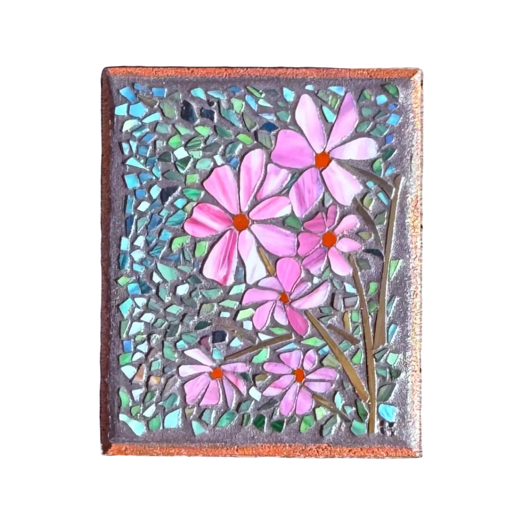 Mosaic artwork on paver of pink flowers on a white surface
