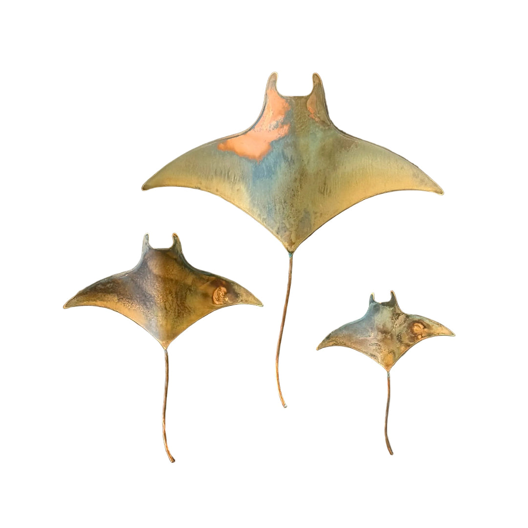 Three copper mata ray wall sculptures on a white background
