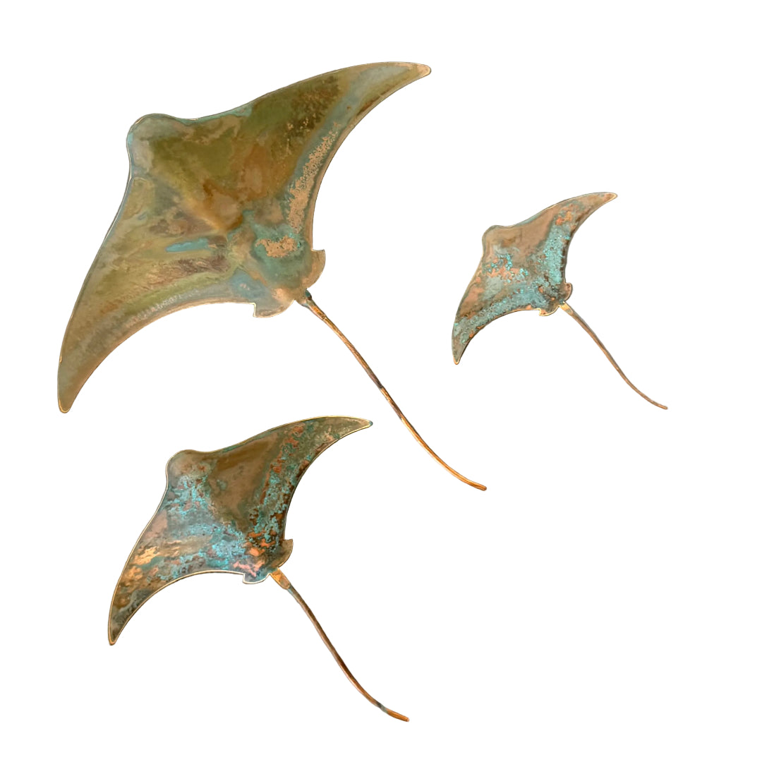 Three copper stingray wall scuptures on a white background
