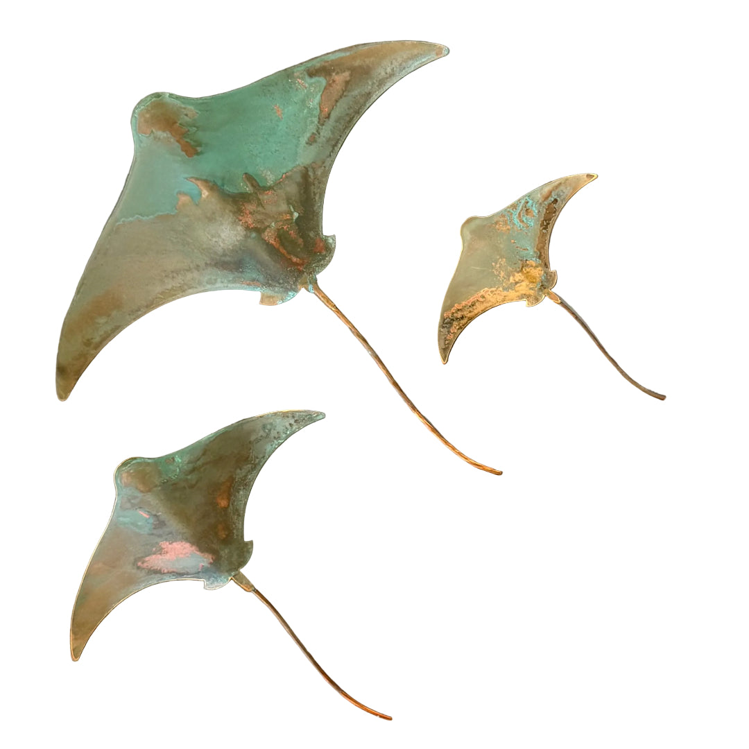 Three copper stingray wall scuptures on a white background