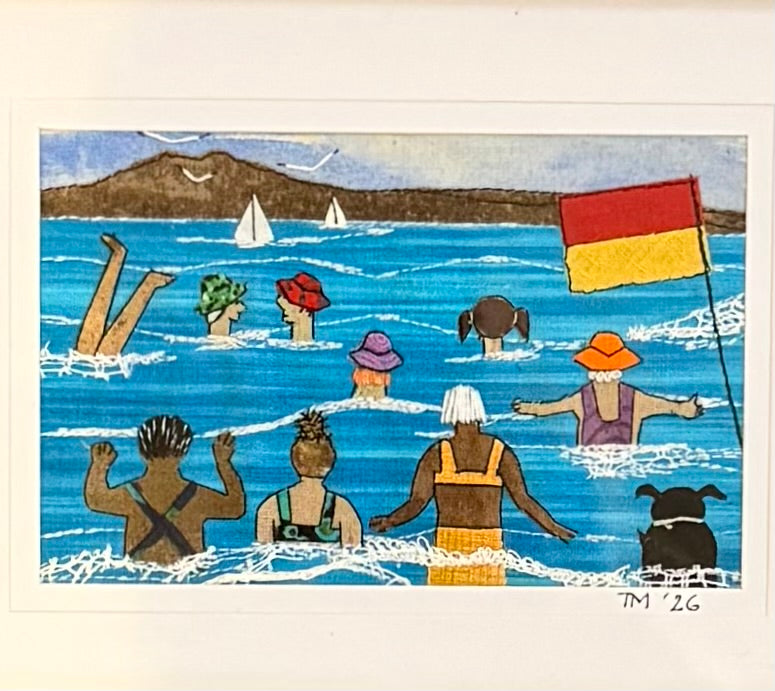 Textile artwork of people swimming at a beach with a flag and sailboats in the background.
