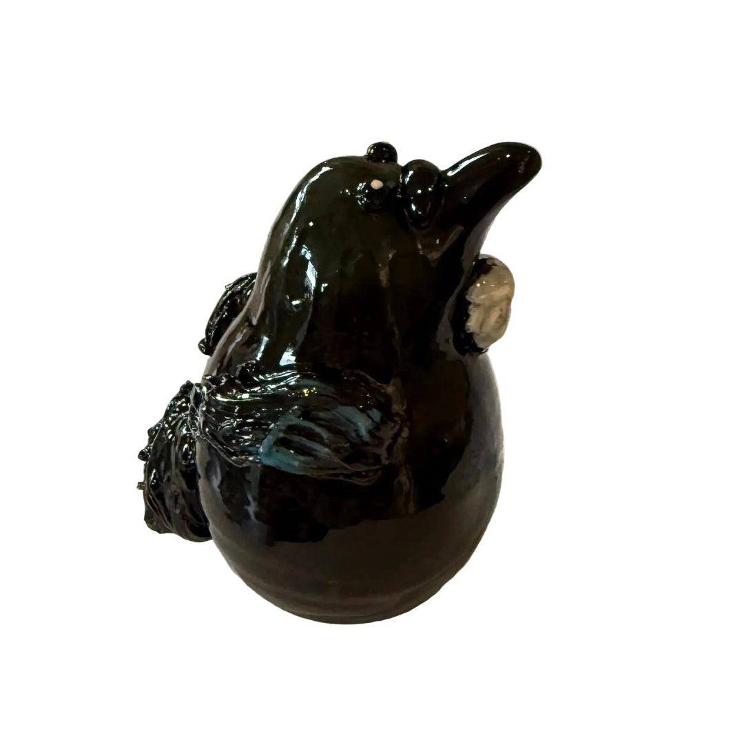 lack & blue ceramic Tui bird sculpture on a white background