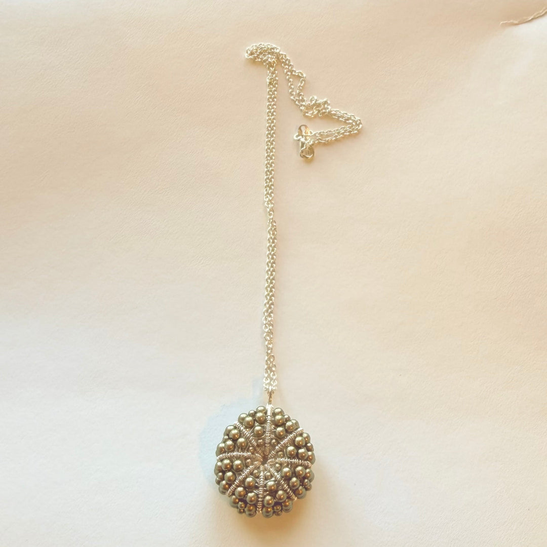 Necklace with a textured pendant on a beige background