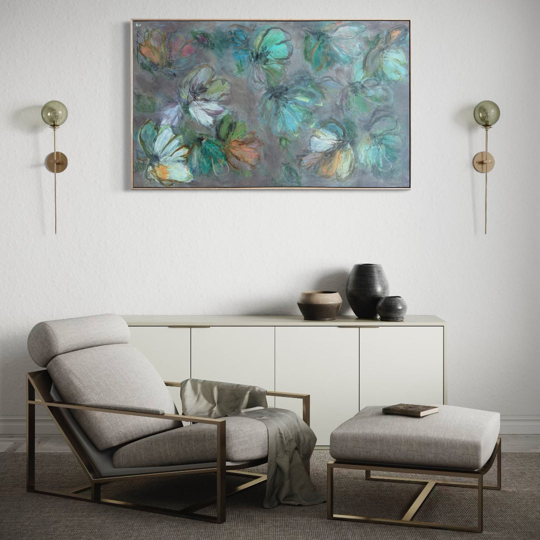 Modern living room with a gray armchair, ottoman, and decorative wall art.