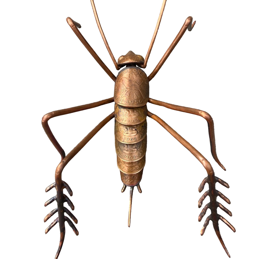 Copper Weta sculpture on a white surface