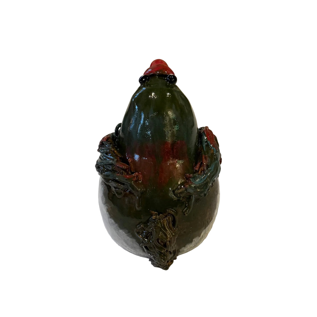 Back view of a ceramic Kereru bird sculpture with a red beak on a white background