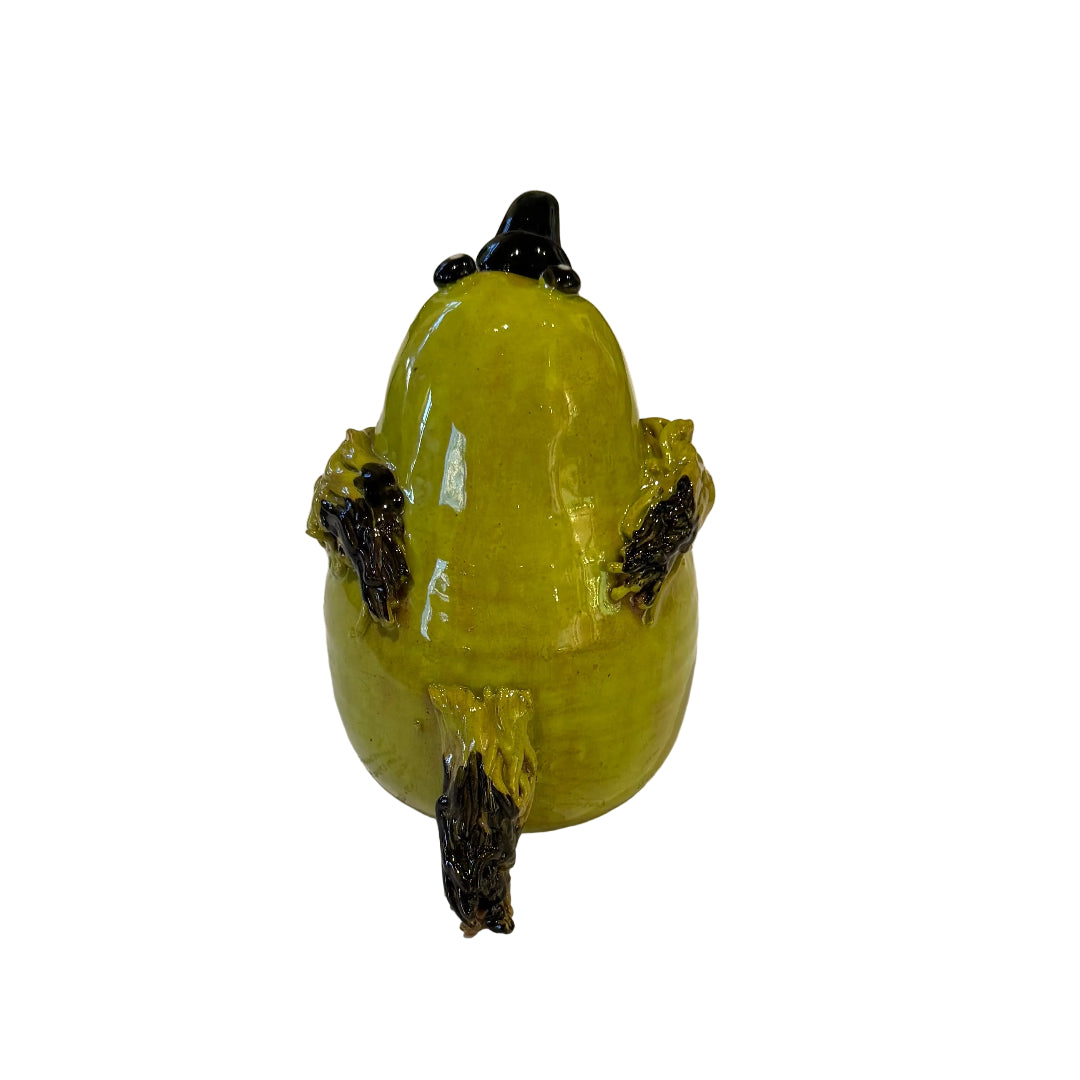 Back view of a ceramic Bellbird sculpture with a black beak on a white background