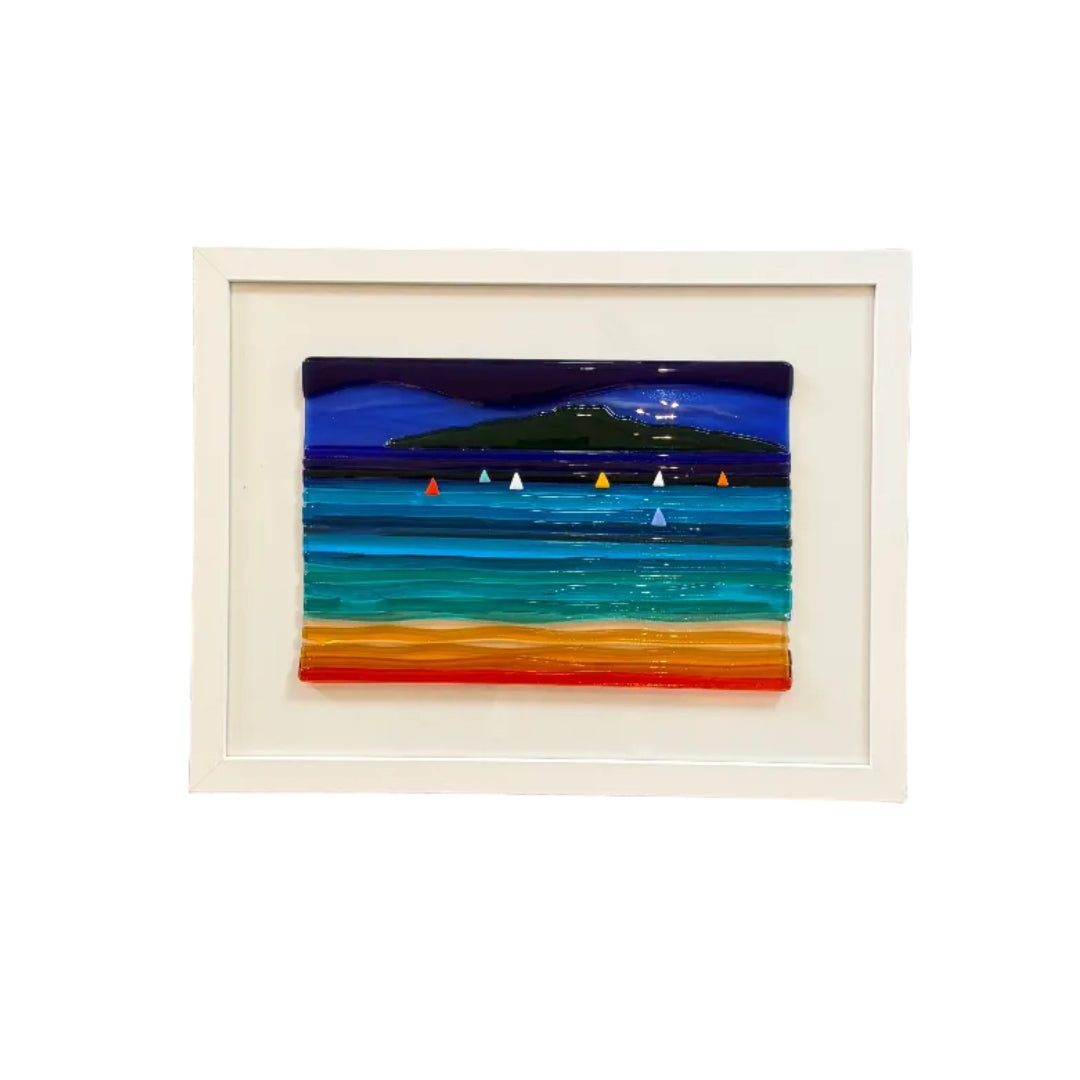 A framed coastal artwork with vertical blue, green, yellow, orange, and red stripes in a white frame.