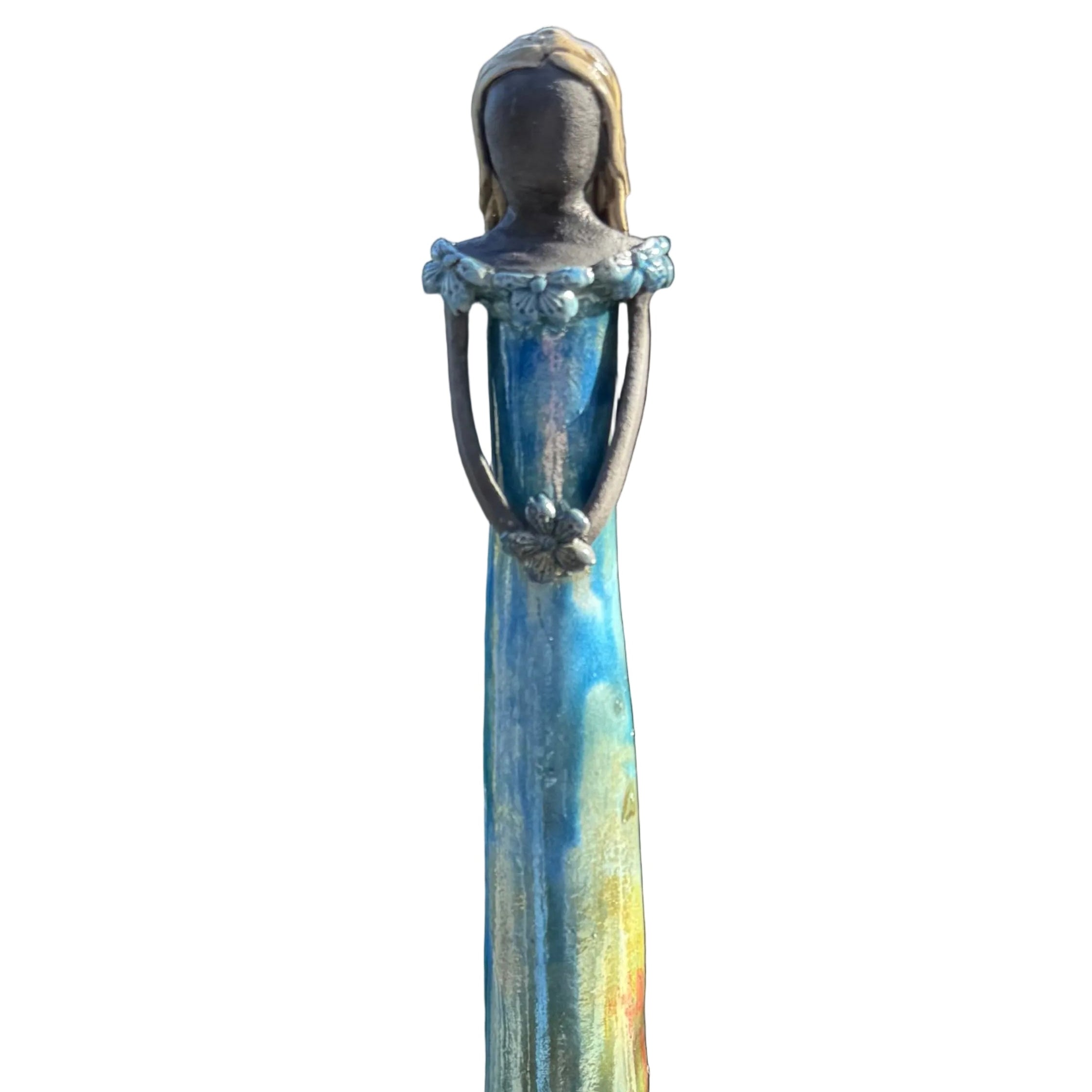 A tall, slender garden statue of a woman in a flowing dress, standing on a white surface.