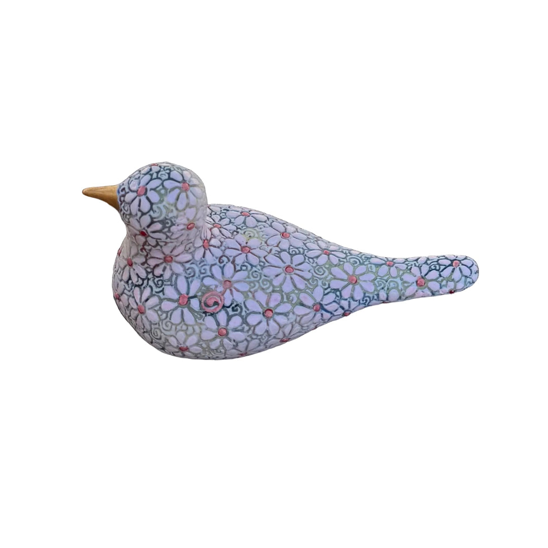 A decorative bird figurine with a colorful floral mosaic pattern on a white base, resting on white background.