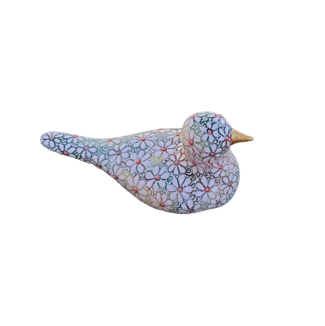 A decorative bird figurine with a light lavender-pink base covered in a dense, multicolored floral and geometric pattern, featuring a small gold-toned beak.