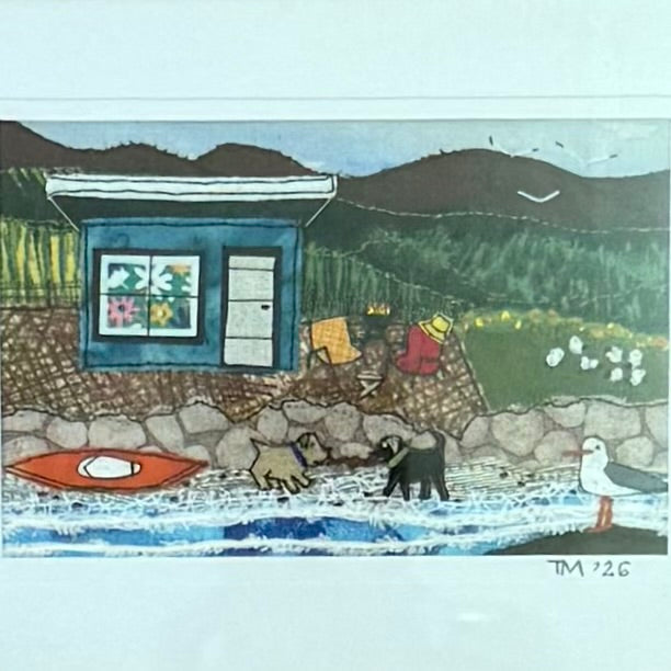 Close up of a small textile landscape artwork depicting a blue bach on a white background.