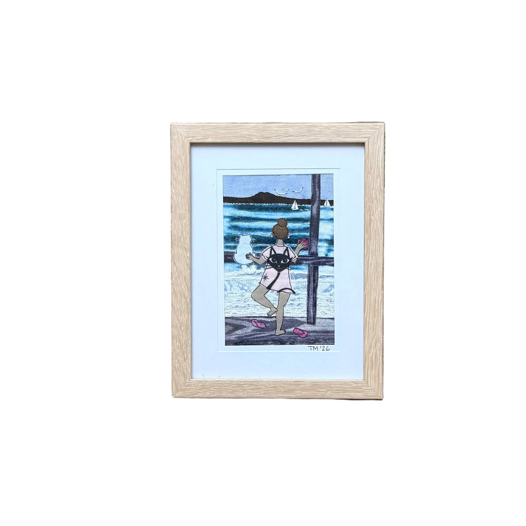 Textile artwork of a dancing girl with a cat looking out to sea.
