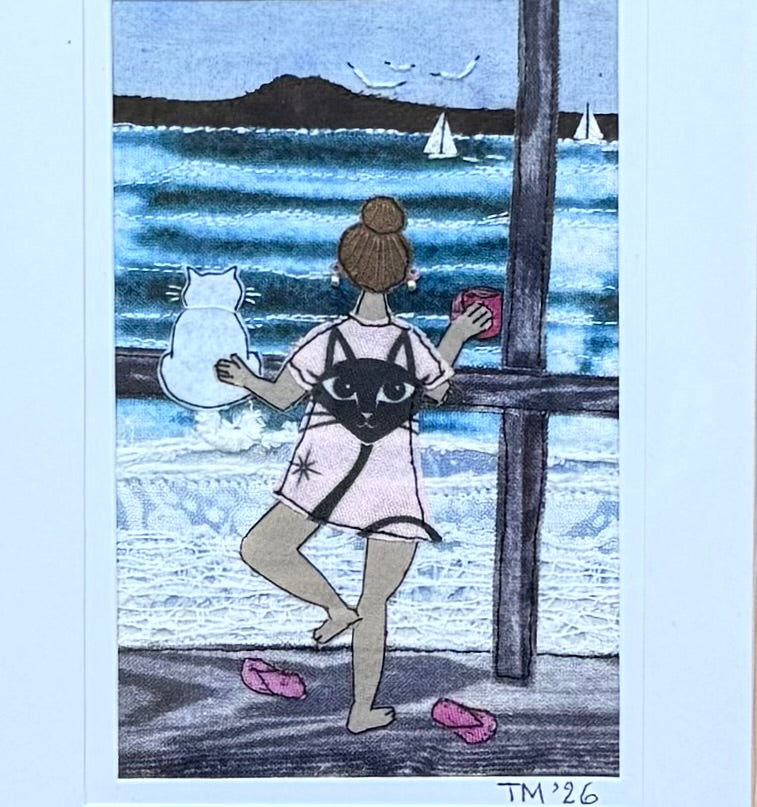 Textile artwork of a dancing girl with a cat looking out to sea.