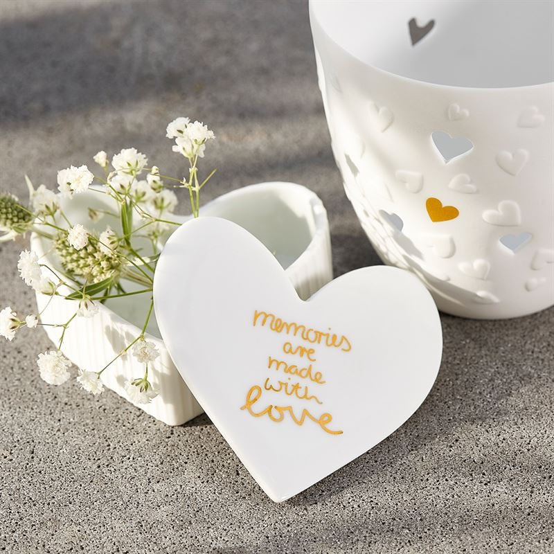 White fluted porcelain trinket box with 'Memories are made with love' written on the lid in gold.