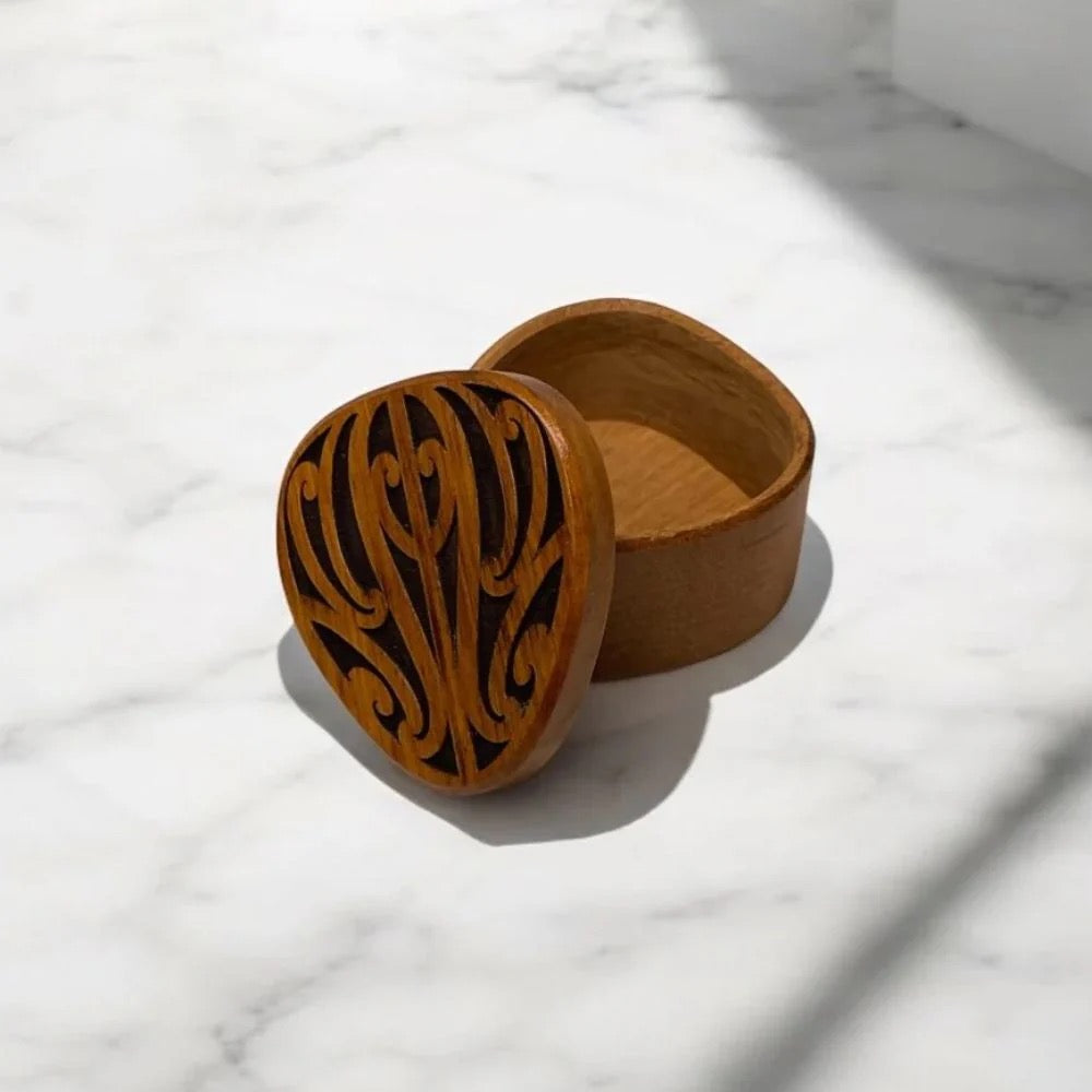 Wooden box with intricate carvings on a marble surface