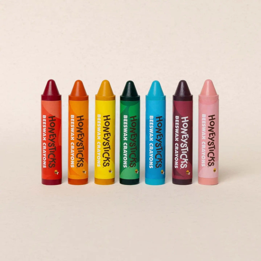 Set of colorful crayons labeled 'Honeysticks' on a beige background