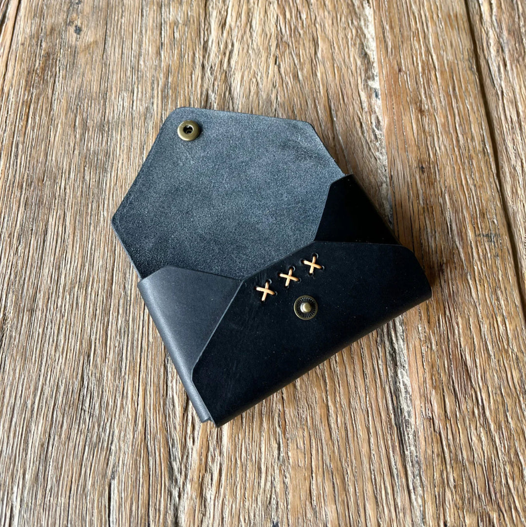 Black leather wallet with gold accents on a wooden surface