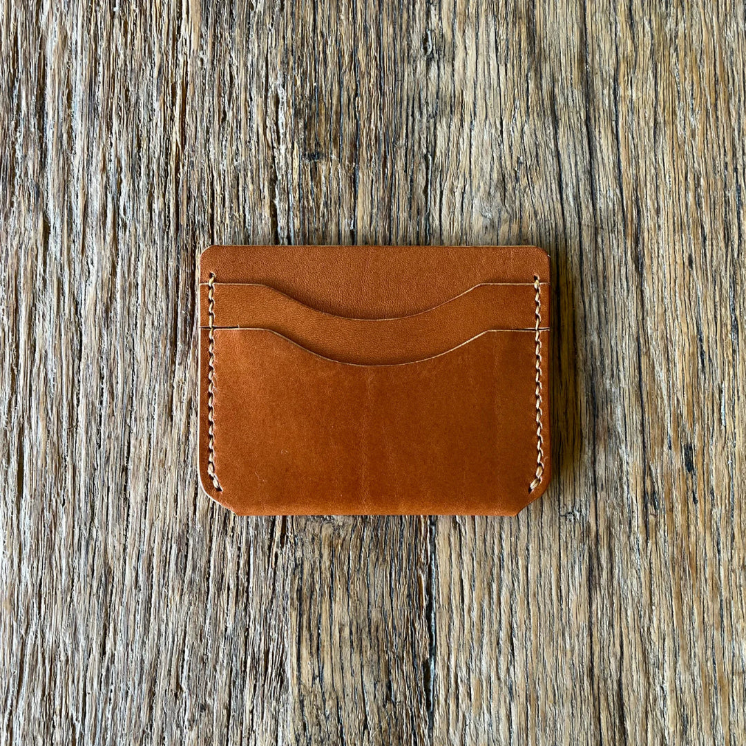 Brown leather cardholder on a wooden surface