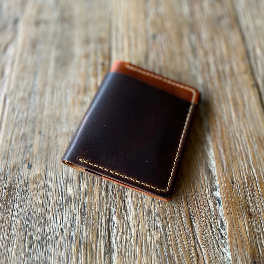 Brown leather wallet on a wooden surface
