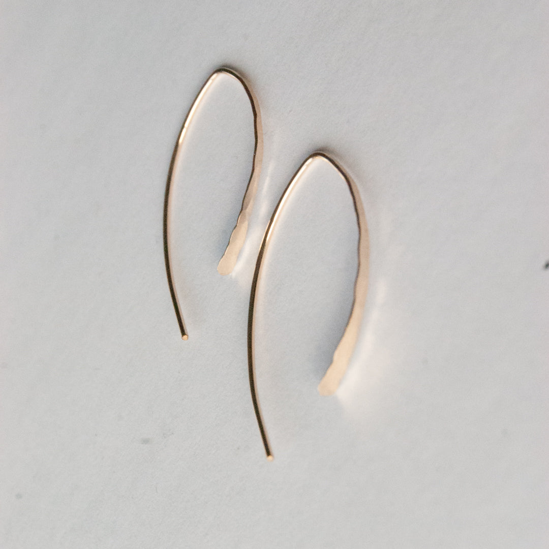 Gold hoop earrings on a light gray background
