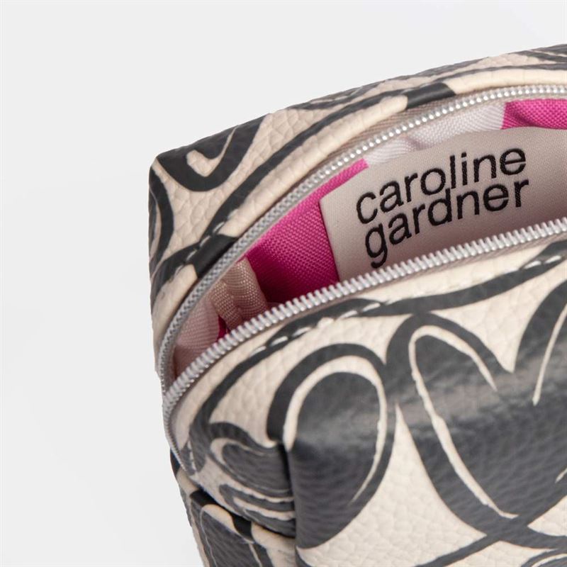 Cosmetic bag with 'caroline gardner' label and floral pattern on a white background