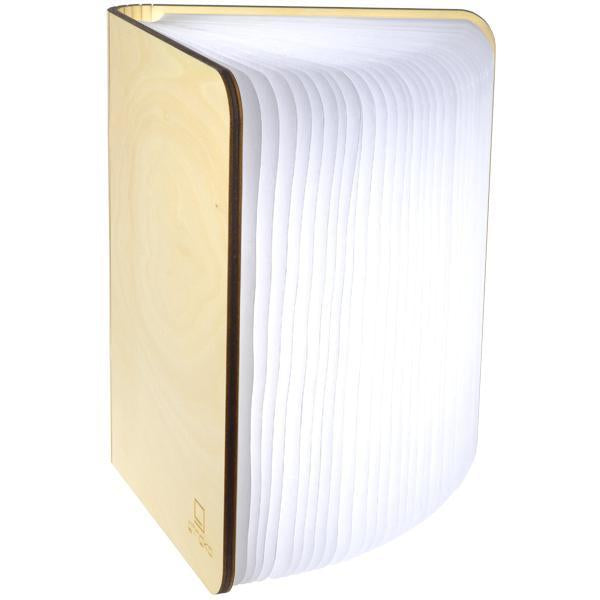 A modern book-shaped lamp with a light natural wood cover and a glowing white pleated page design, shown on a plain white background.