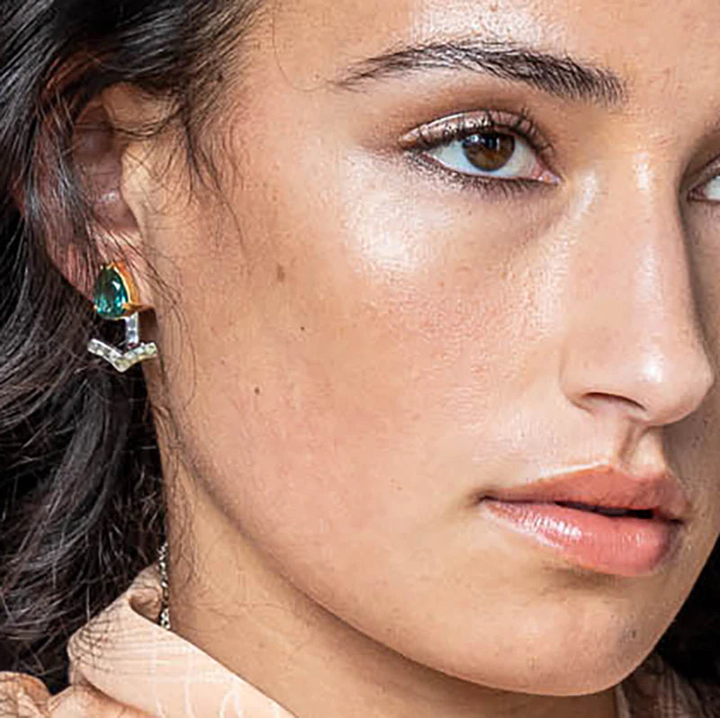 Close-up of a woman's face with a focus on her earrings.