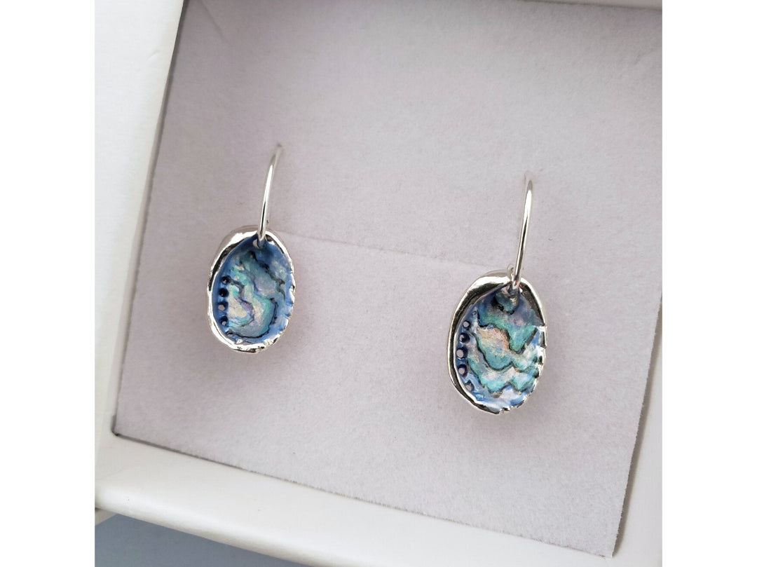 Pair of painted multicoloured silver Paua Shell earrings on a gray card