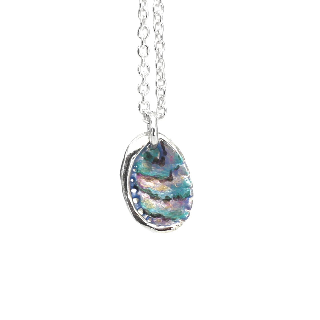 Hanpainted muliticoloured Paua Shell pendant necklace with a silver chain on a white background