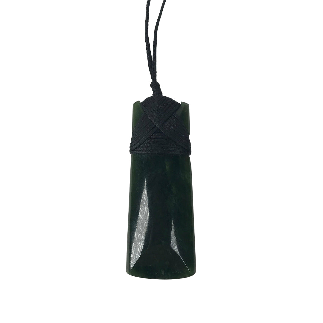 A greenstone pendant, carved and polished to a smooth finish, with a dark cord necklace.