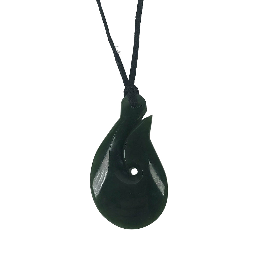 A greenstone carved hook pendant with a black adjustable cord.
