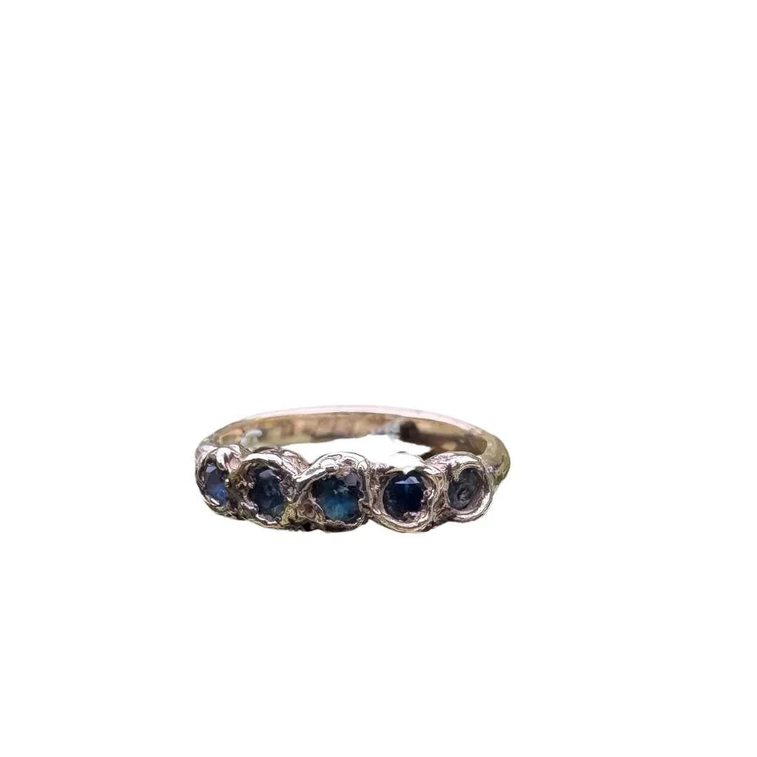 Gold ring with 5 sappires on a white background