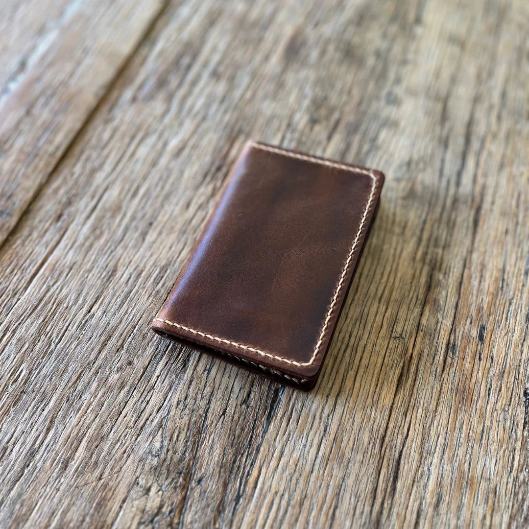 Brown leather wallet on a wooden surface