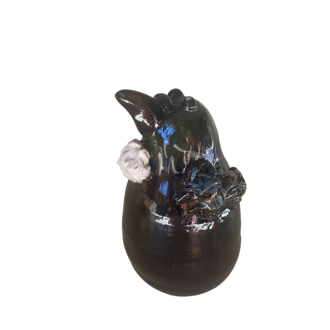 Black & blue ceramic Tui bird sculpture on a white background