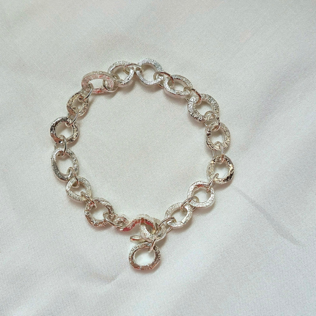 Silver chain bracelet on a white fabric background