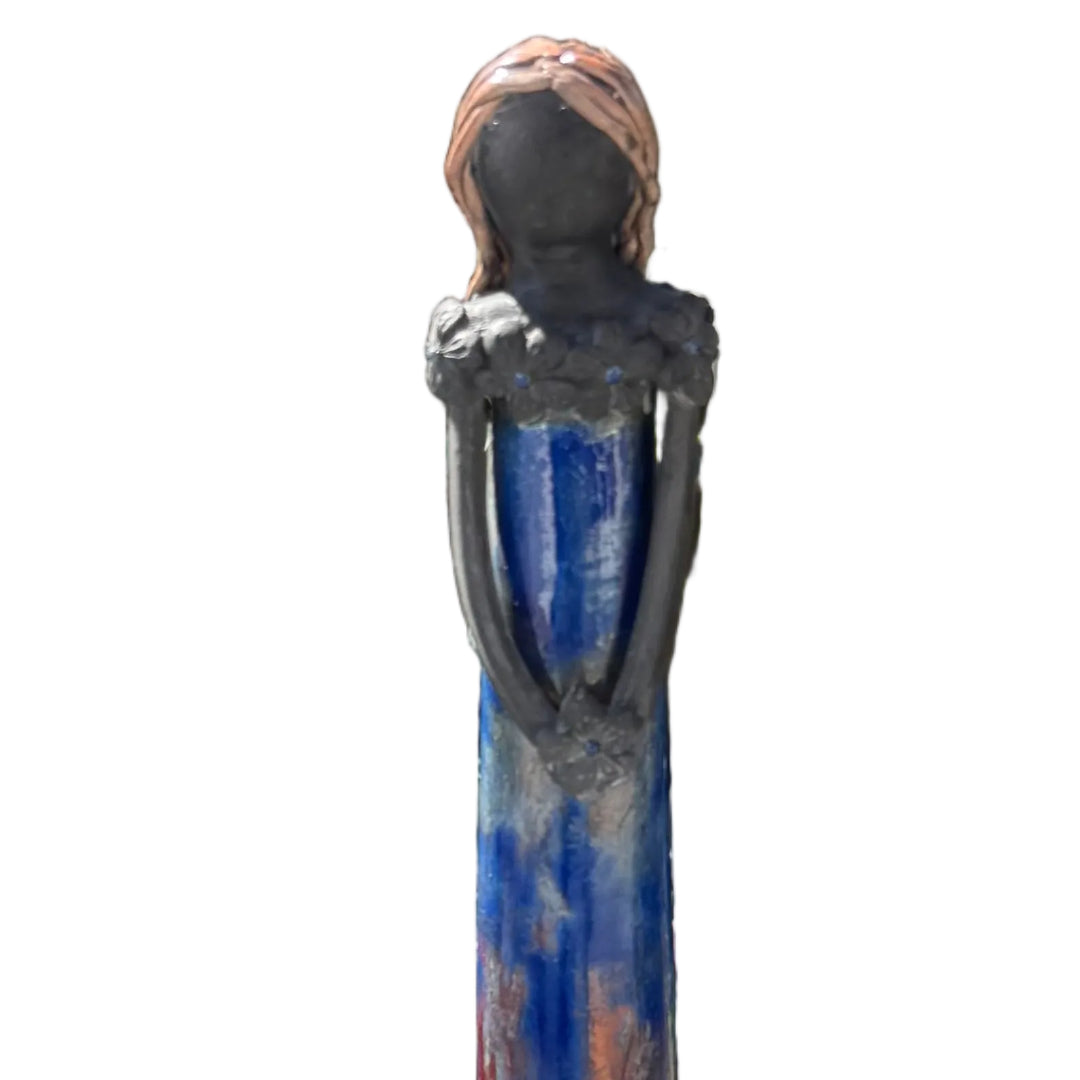 Close up view of a ceramic tall lady figurine  holding a dark flower against a white back ground.