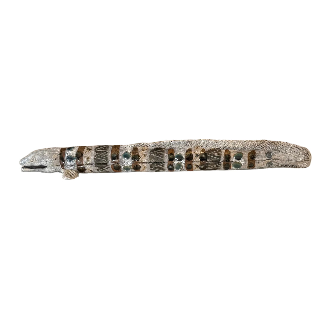 A ceramic sculpture of an eel with natural colorful patterns.