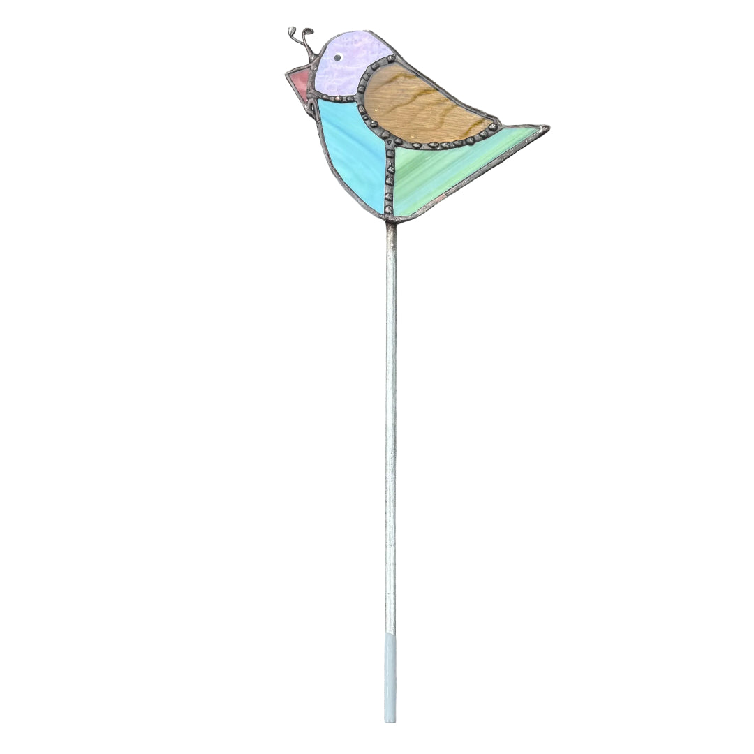 A decorative metal bird garden stake with a long silver stem, featuring a bird design with a purple head, brown wing, blue & green body, and red beak, set against a white background.