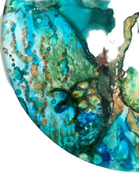 Close-up of a round colorful abstract pattern with blue, green, and brown hues on a white background.
