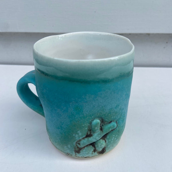 Turquoise Cup with X and 3 Staples
