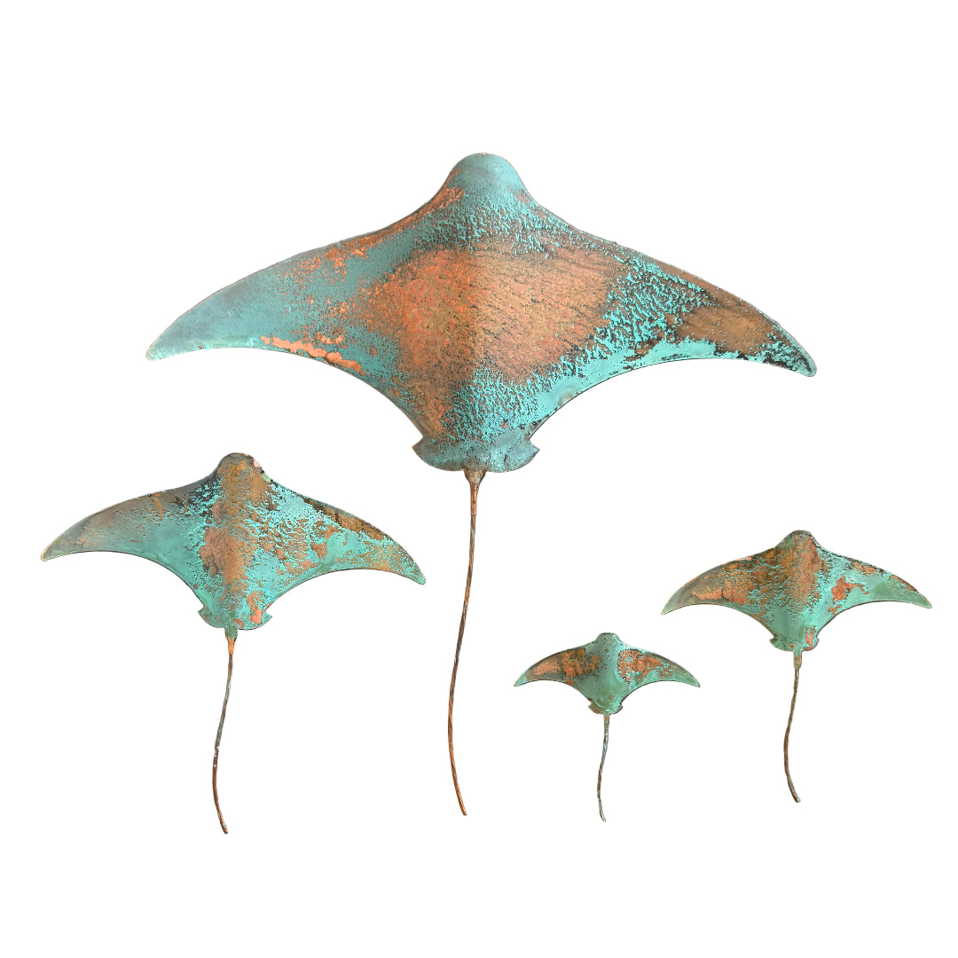 Set of four copper stingrays with a patina finish on a white background