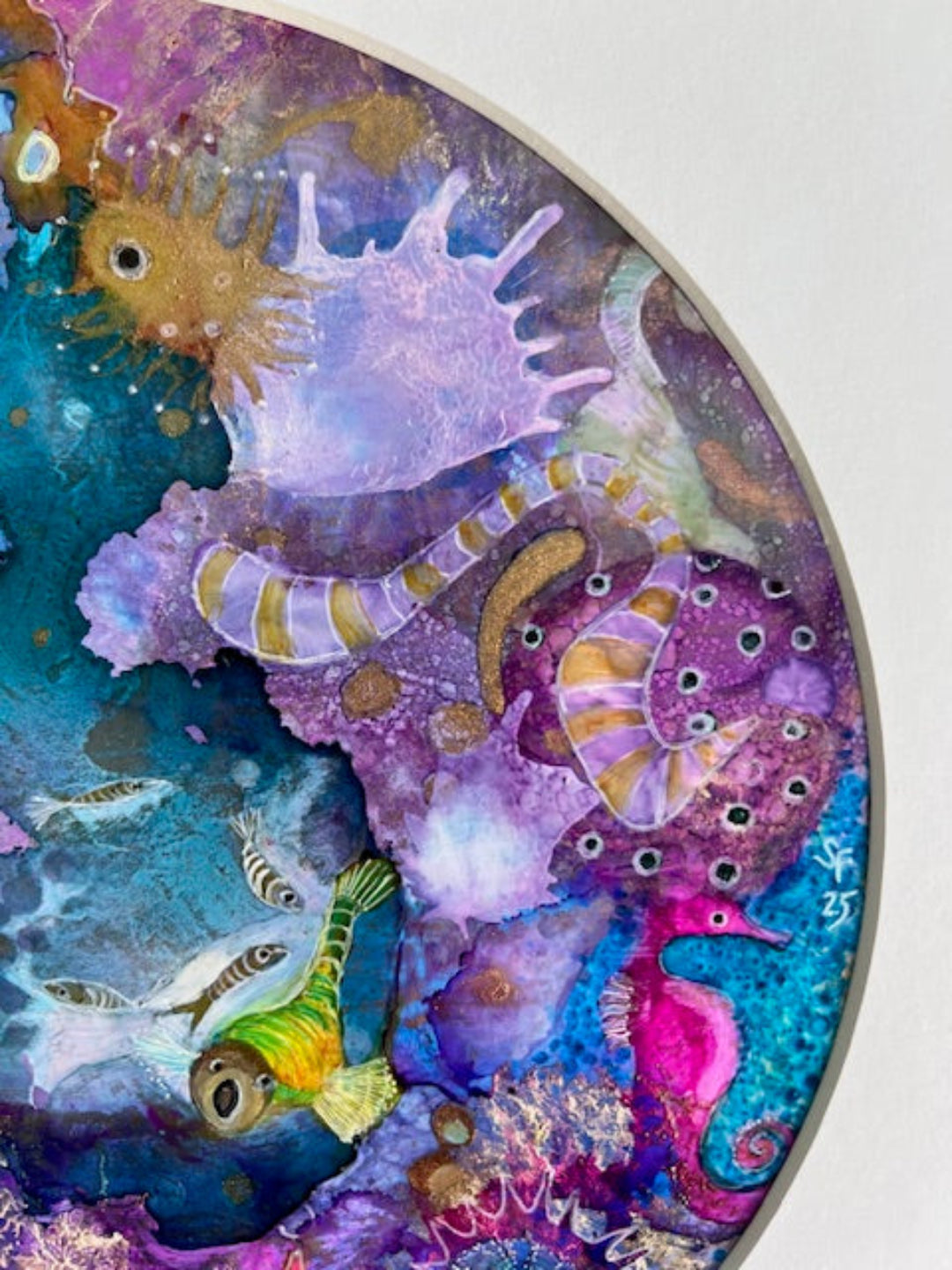 Colorful underwater scene with seahorses and fish on a circular painting.