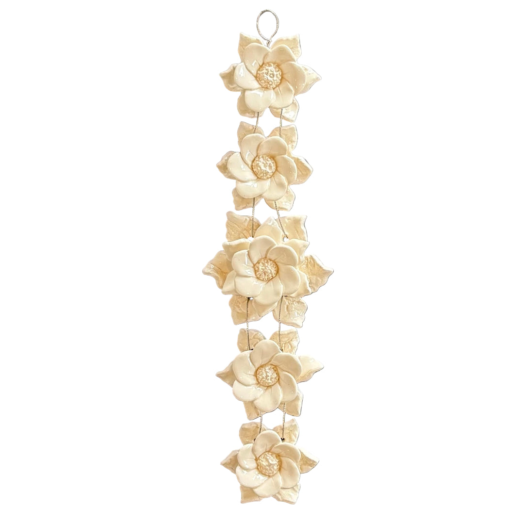 Decorative hanging with ceramic cream-colored flowers on a white background