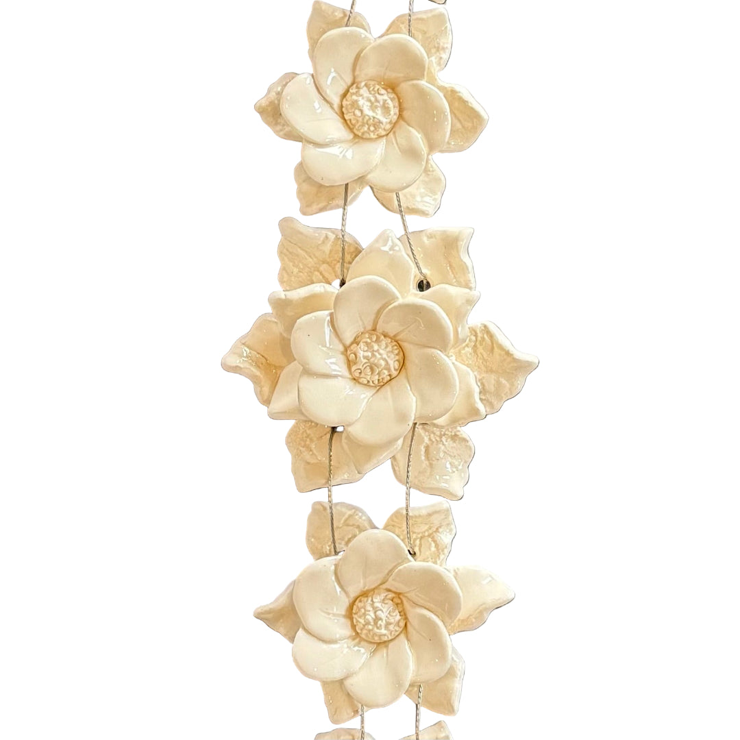 Decorative wall art with ceramic cream  flowers on a white background