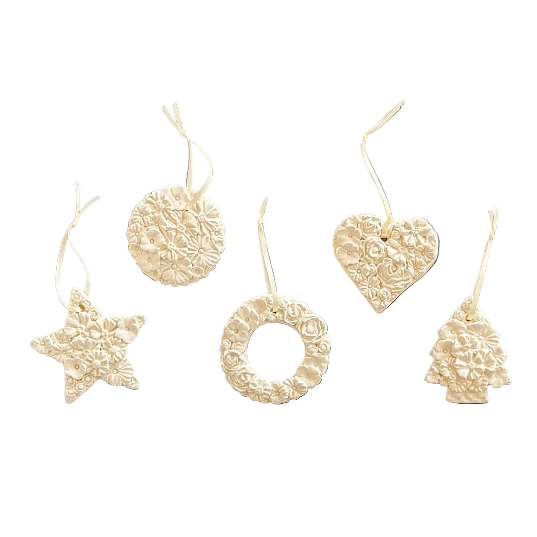 Set of white textured floral ceramic hanging decorations or Christmas ornaments on a white background