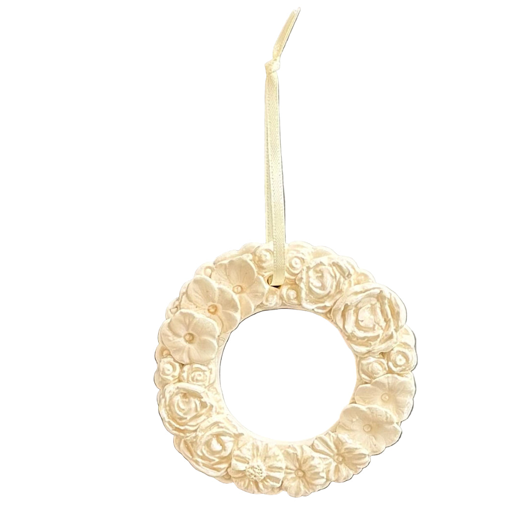 Decorative white ceramic wreath ornament on a white background