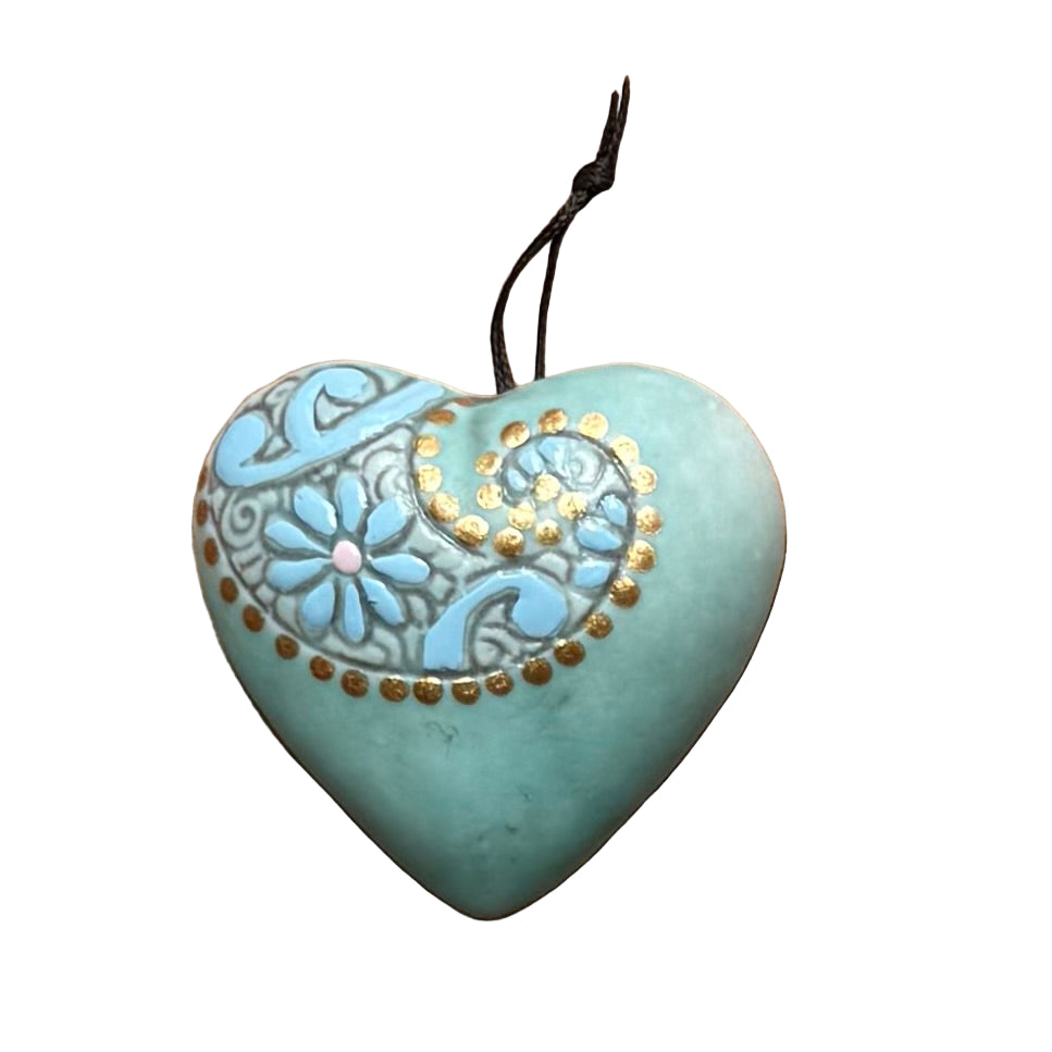 Turquoise ceramic hanging heart with gold embossing on a white surface