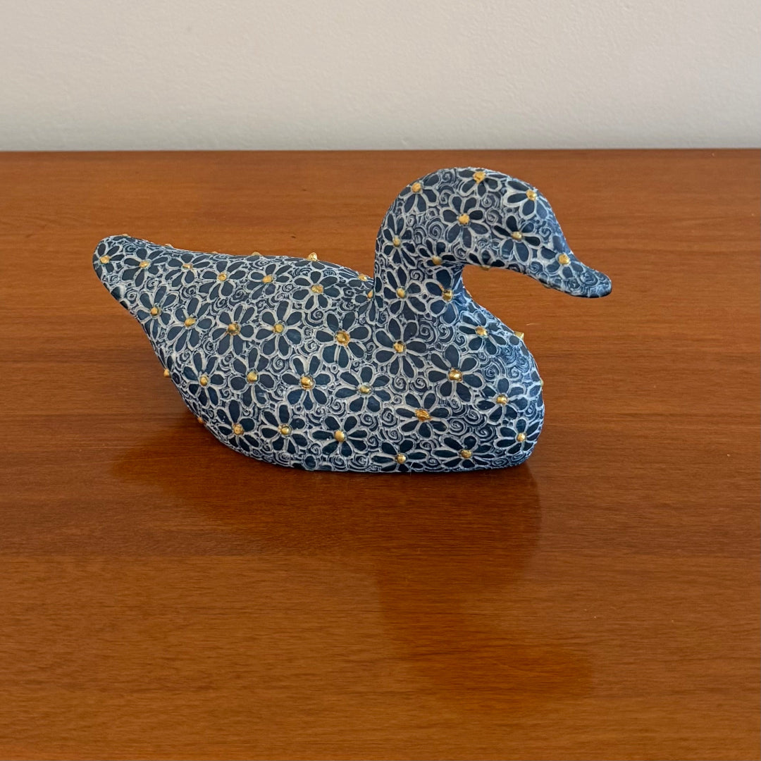Decorative duck with floral pattern on a wooden surface
